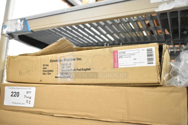 Two-tier lot with Dominion Blueline desk calendars in labeled boxes, Lysol cleaner, wire glove box holder, Purell soap.