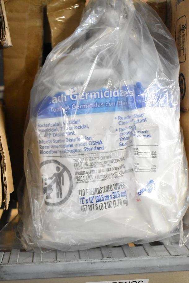 Bundle of cleaning products and supplies in packaging, including germicidal wipes. Contains safety and usage labels.