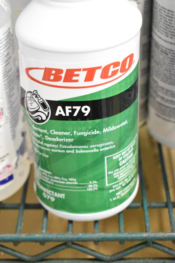 Betco AF79 disinfectant bottle on shelf, part of a two-tier auction lot. Clear label detailing its cleaning properties.