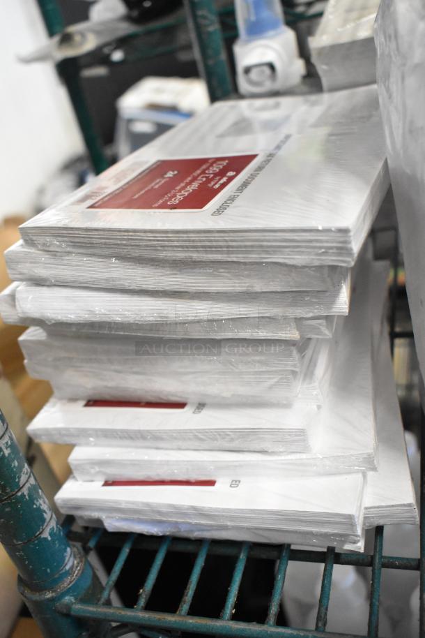 A stack of shrink-wrapped 1099 envelopes on a metal shelf, labeled for various office uses.