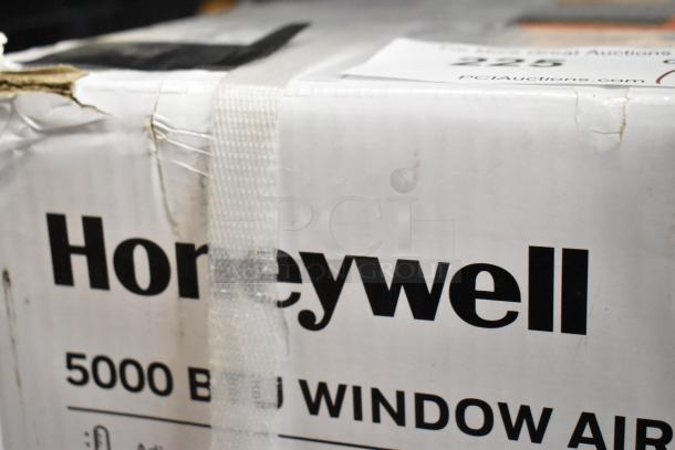 Brand new Honeywell HAC5 5,000 BTU window air conditioner in damaged box. Visible branding and capacity on packaging.