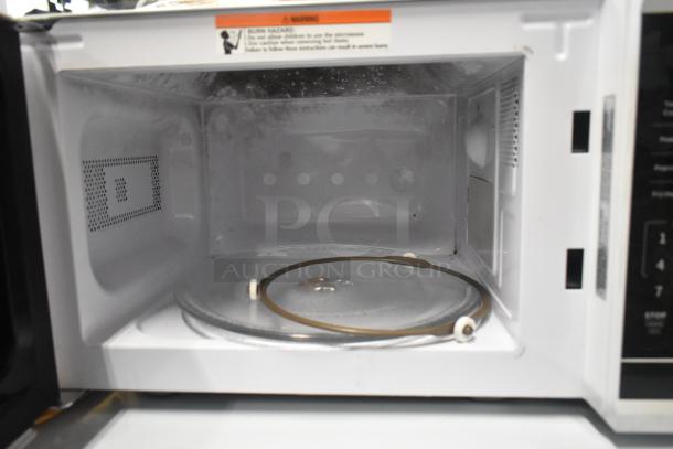 Brand new Vissani EM720C2KHWCL 0.7 cu. ft. microwave, 700-Watt, with scratches and dents. Interior view, includes glass turntable.