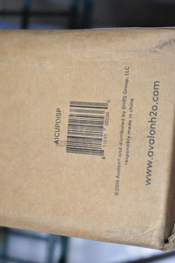 Cardboard box labeled "A1CUPDISP" with a barcode and www.avalonh2o.com, indicating Avalon distribution. Box slightly dented.