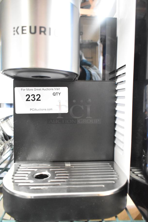 Keurig K-2550 single cup coffee machine, 115V, 1 phase. Features sleek design, visible branding, and drip tray. Tag reads "232."