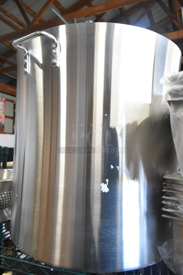 Stainless steel stock pot, new with minor dents, reflective surface, sturdy handles, part of 12 assorted kitchen items.