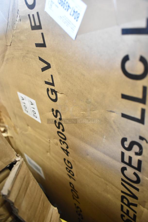 Cardboard box labeled "GLV LLC." Contains 10 new scratch-and-dent items, including a pan rack and baby changing station.