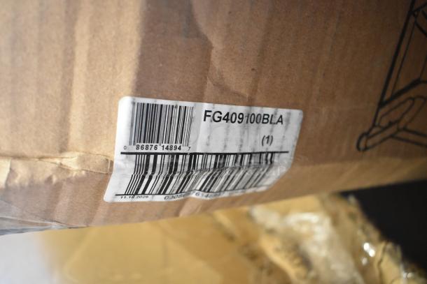 Cardboard box showing label with barcode and model number FG409100BLA, containing scratch and dent items like a pan rack and baby changing station.