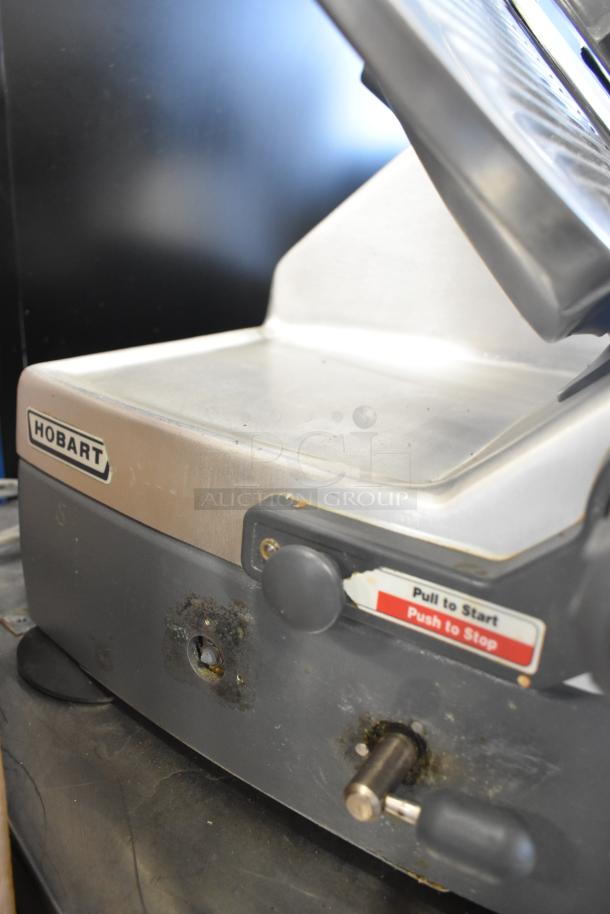 Hobart 2912 commercial semi-automatic meat slicer, visible wear, 115 volts, 1 phase, with start/stop control label.