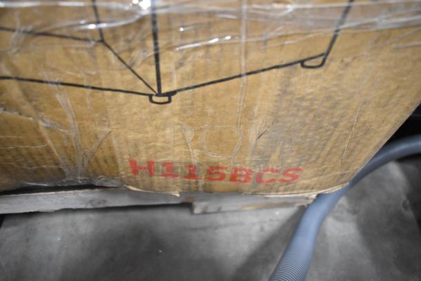 Cardboard box with model number H115BCS, indicating Honeywell cooler inside. Box shows signs of wear.