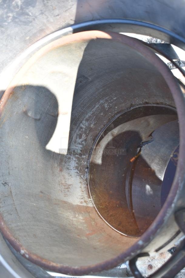 Metal mixing bowl on bowl dolly, showing interior wear and rust, suitable for industrial kitchen use.