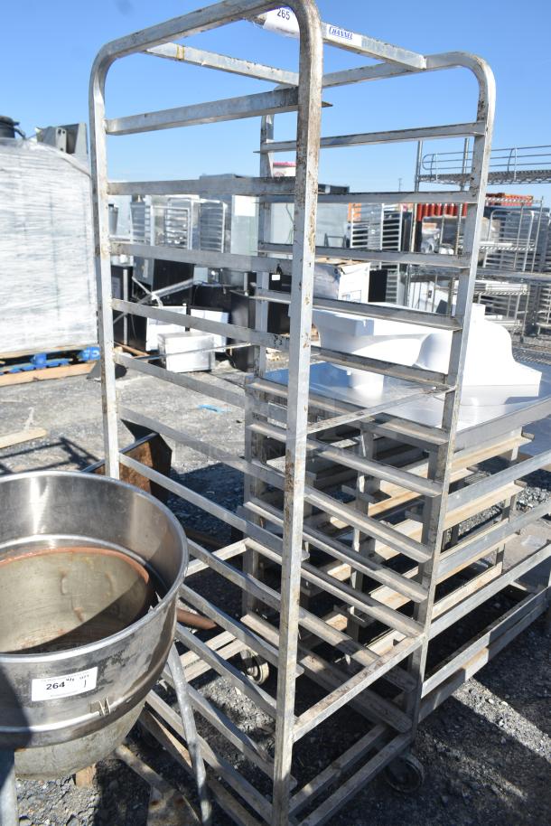 Channel Metal Commercial Pan Rack with multiple shelves on commercial casters. Shows slight wear. Ideal for kitchen use.