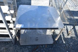 Commercial table with metal under shelf, visible wear, sturdy metal frame. Tag reads "267." Ideal for industrial use.