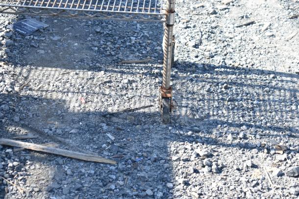 Chrome finish 4-tier wire shelving unit with caster wheels, visible rust. Buyer must dismantle, consider freight charges.