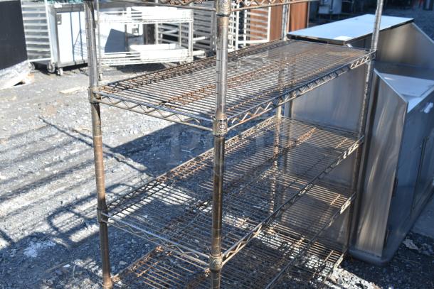 Chrome finish 6-tier wire shelving unit, outdoor setting, showing signs of rust. Buyer must dismantle. Freight charges apply.