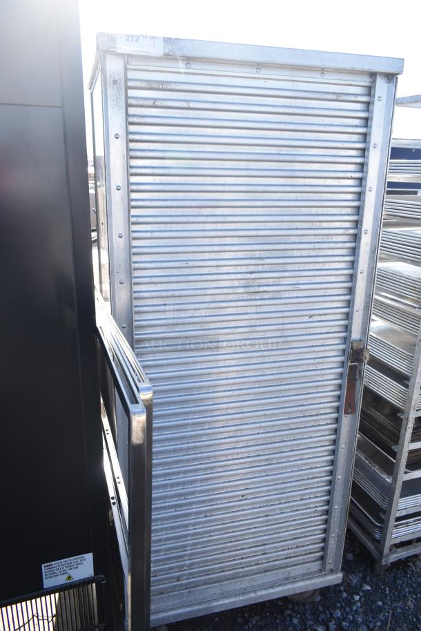 Commercial enclosed pan rack on casters with metal construction, ribbed panels, and locking handle. Appears in used condition.