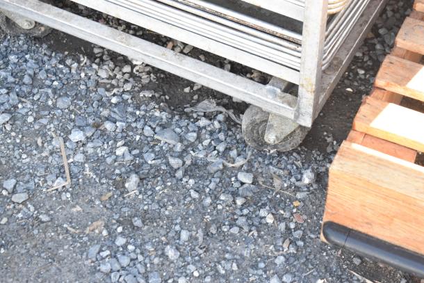 Channel commercial pan transport rack with commercial casters, holding 50 baking pans. Suitable for bakery use, outdoor setting.