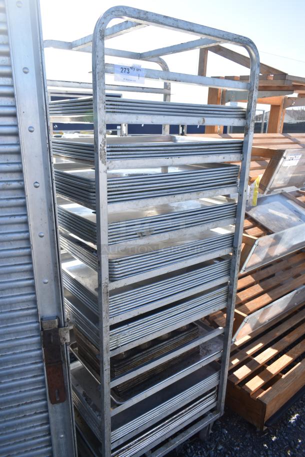 Channel commercial pan transport rack on casters with 50 baking pans. Features durable metal frame and used condition.