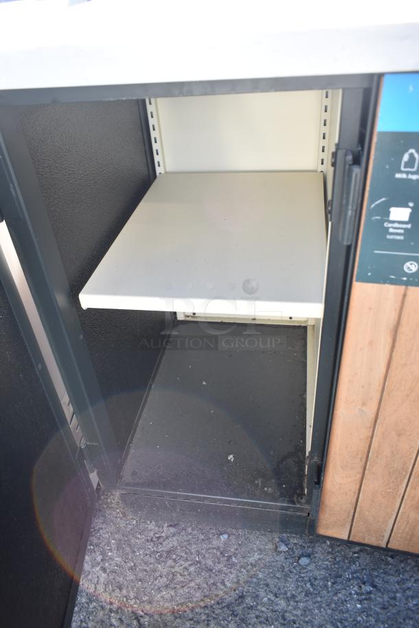 Trash can shell with trash deposit holes, featuring a black interior and wooden doors. Some wear visible.