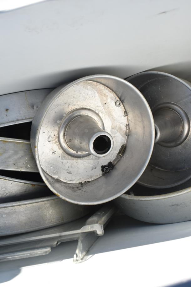 White poly ingredient bin on casters, filled with round cake pans, showing signs of use.