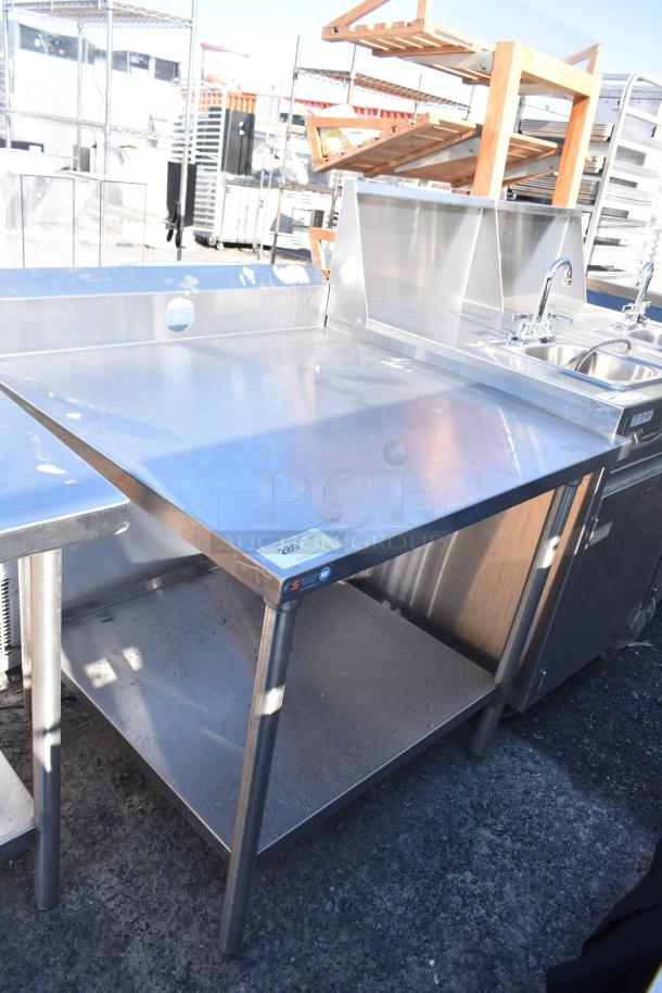 Stainless steel commercial table with under shelf, used condition, features smooth top and sturdy construction, visible label.