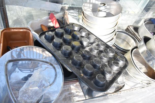 Four-tier chrome wire shelving unit on commercial casters, includes baking supplies, requires buyer dismantling.