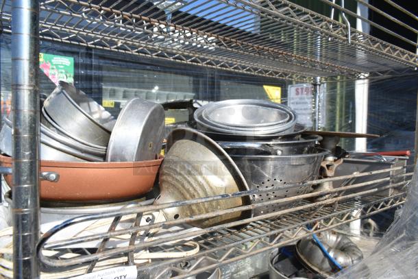 Chrome finish 4-tier wire shelving unit on commercial casters, loaded with various kitchenware items. Buyer must dismantle.