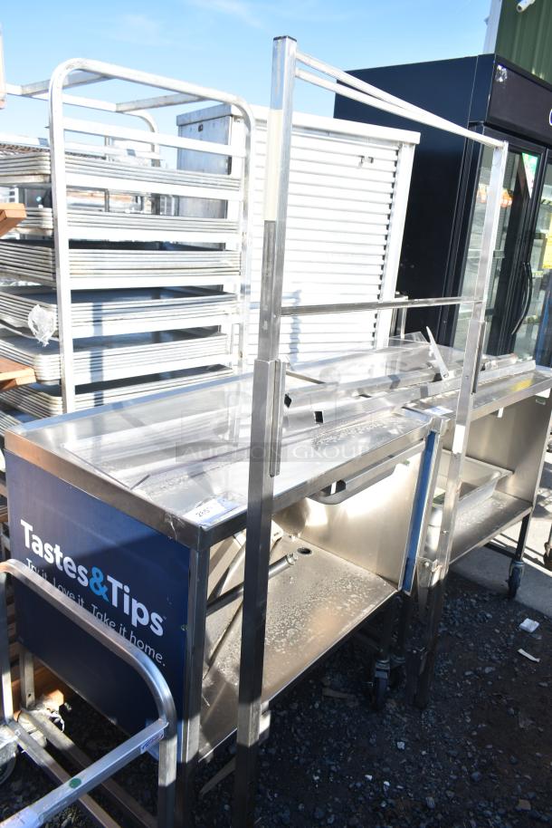 "Commercial portable counter with under shelf and drawer on casters, labeled 'Tastes & Tips,' featuring sturdy metal frame."