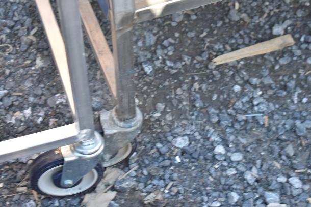 Commercial portable counter with under shelf, drawer, and commercial casters, shown focusing on sturdy metal legs and wheels.