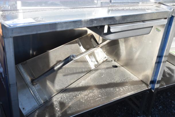 Commercial portable counter with under shelf and drawer on casters, stainless steel, in used condition, ideal for catering.