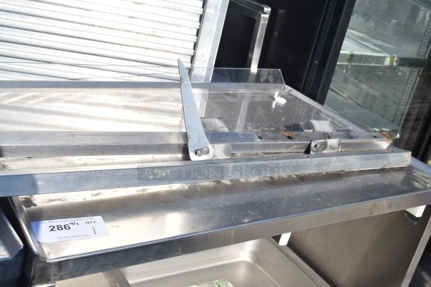 Commercial portable counter with under shelf and drawer, on casters. Stainless steel finish, minor wear visible, tag reads "286".