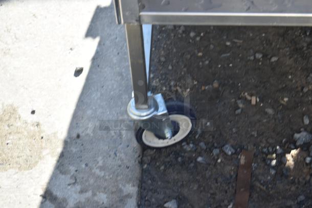 National Cart commercial portable counter leg and caster on asphalt, featuring durable construction and mobility.