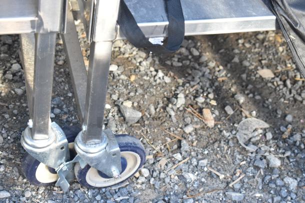 National Cart portable counter on commercial casters with under shelf and drawer, shown in used condition.