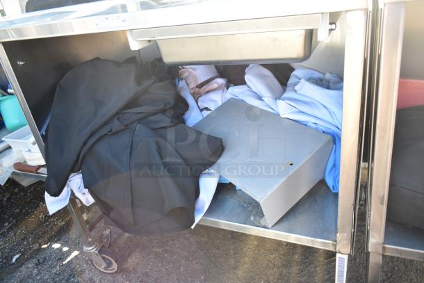 National Cart commercial portable counter with under shelf, drawer, and commercial casters. Visible wear on surface.