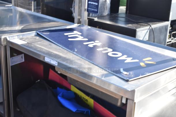 National Cart commercial portable counter with contents, under shelf, and drawer on commercial casters. Sign reads "Try it now."