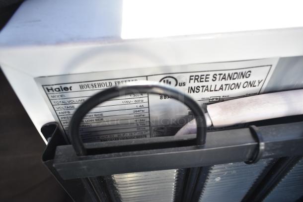 Label on Haier freezer showing model, voltage, amps, and installation instructions. Part of an auction lot with 6 mini coolers.