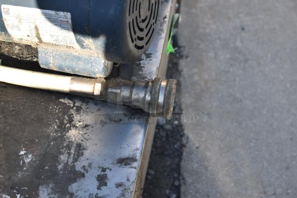 Industrial equipment with visible metal fittings and hose attachment, slight wear, suitable for heavy-duty use.