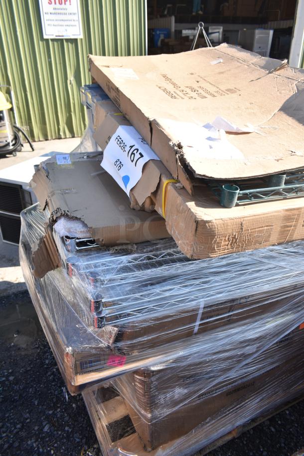 Stack of nine brand new scratch and dent items, including wire shelves and wall shelf, wrapped on a pallet. Packaging shows wear.