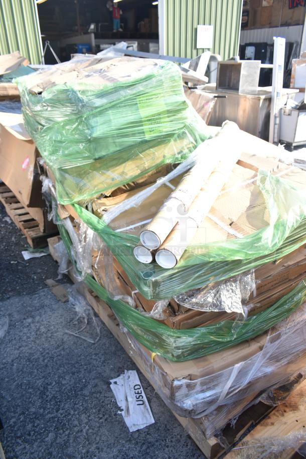 Pallet of 12 scratch and dent items, including shelves and pan racks, new in packaging, green wrap and cardboard seen.