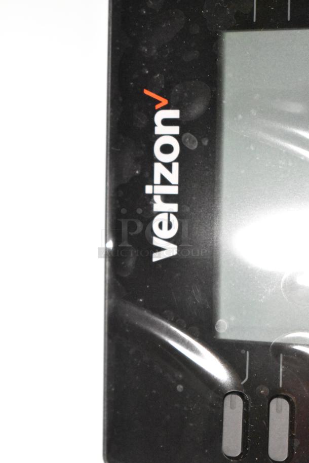 Verizon corded office telephone with a sleek black finish and digital display. Buttons and branding are visible. Slightly dusty condition.