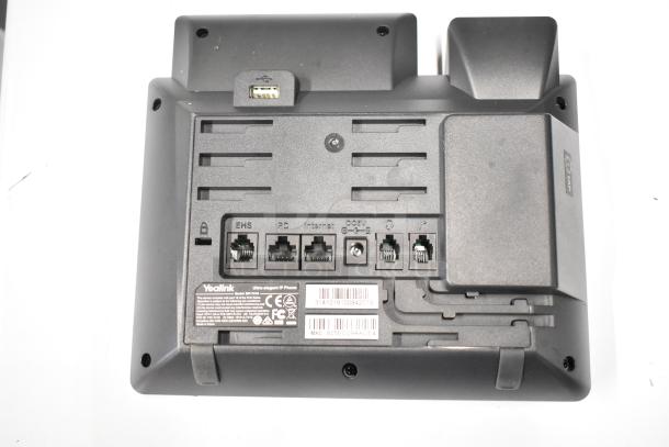 Gray Yealink corded office telephone, rear view showing ports for EHS, PC, Internet, DC power, and serial labels.