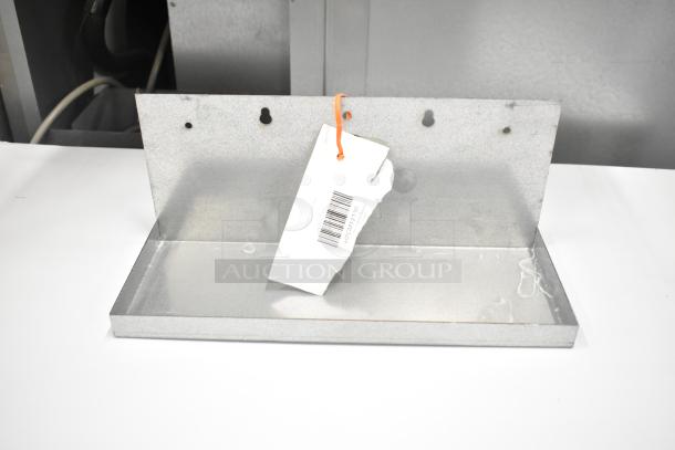 Metal bracket with tag attached, featuring a barcode. Part of a new scratch and dent auction set.