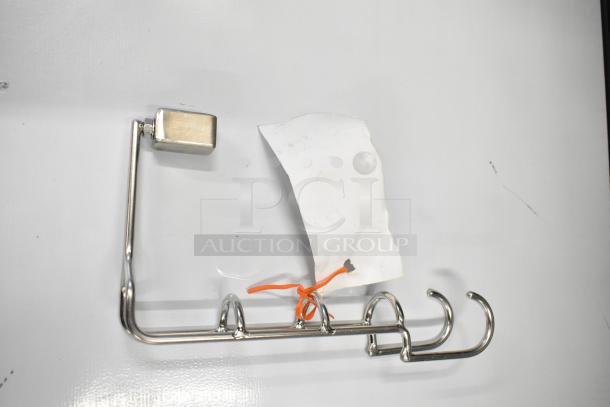 Chrome brush hanger with four hooks, new condition, slight scratches, includes a mounting component.