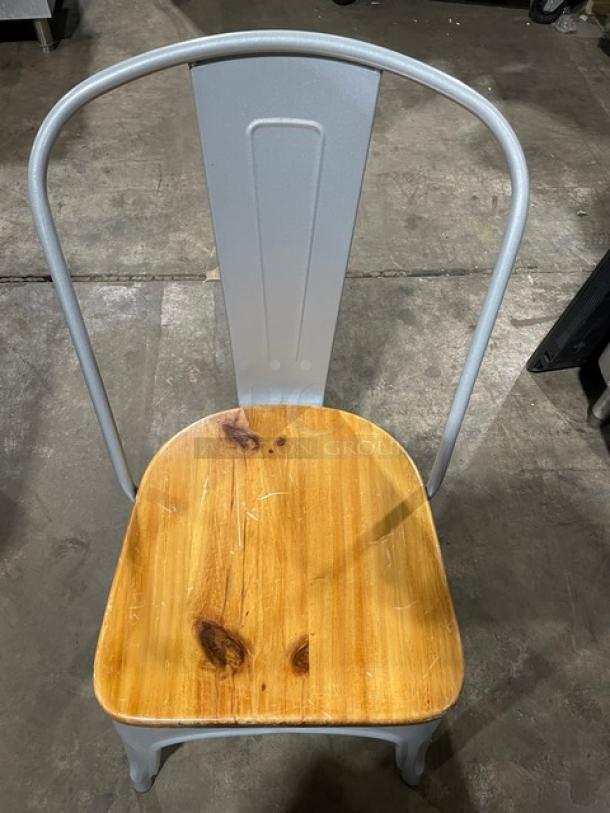 Astor Series silver dining chair with wood seat, welded metal frame, like new condition, suitable for indoor/outdoor use.