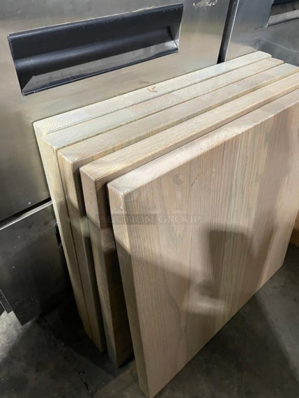 Golden Ash full wood table tops, like new condition, stacked vertically. Natural grain visible; smooth, finished surface.