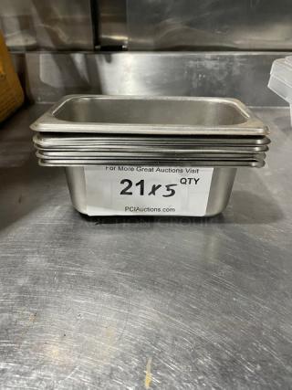 Commercial stainless steel steam table pans, stack of five, in good condition. Label indicates auction lot 21, quantity 5.