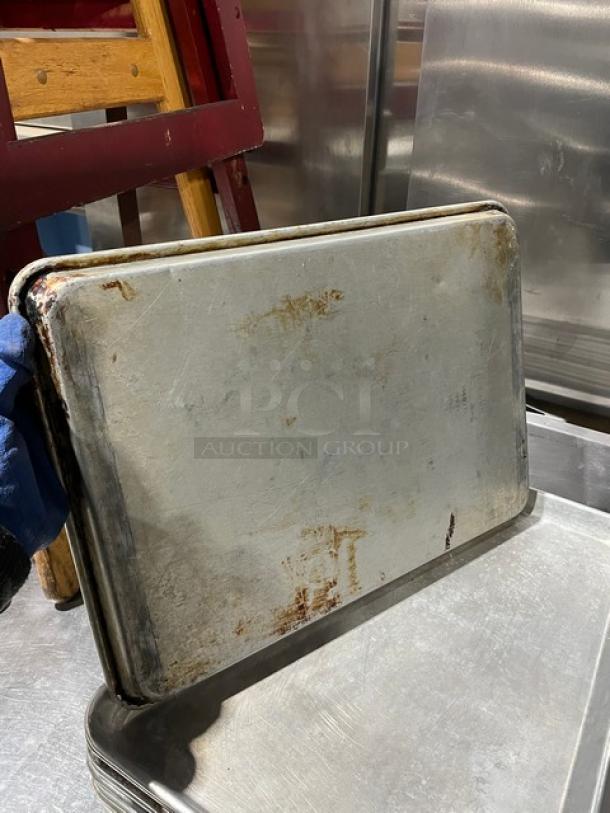 Commercial aluminum baking sheet pan, used condition with visible wear. Bid yields six pans. Sturdy, versatile kitchen essential.