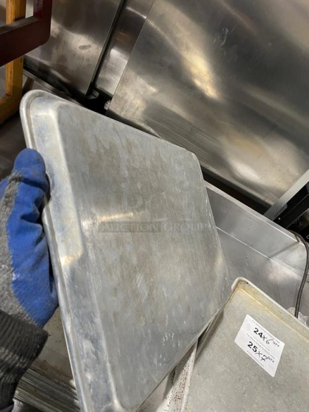 Commercial aluminum baking sheet pan in used condition, with visible wear. Marked "24 x 26" and "25" on tags.