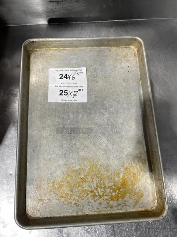 Commercial aluminum baking sheet pan, used, showing wear. Two auction labels visible with web address PCAuctions.com.