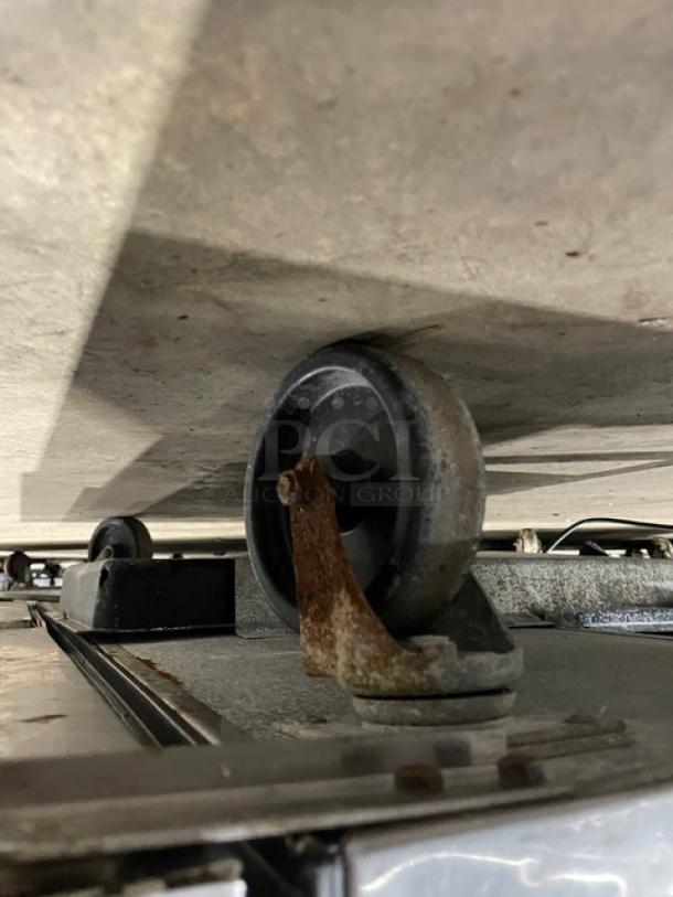 True TWT048 stainless steel 2-door undercounter worktop refrigerator, model TWT0-48, on casters, 115V, lightly rusted caster.