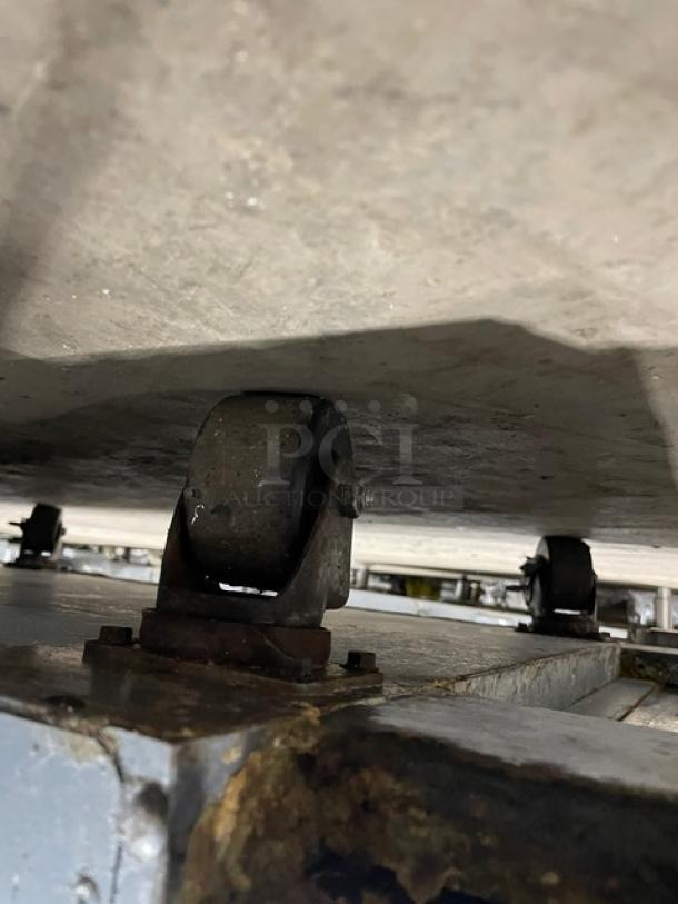 True TSUU4808 stainless steel refrigerated pizza prep table wheel, showing rust and wear. Model: TSUU-48-08 SN: 4940880.